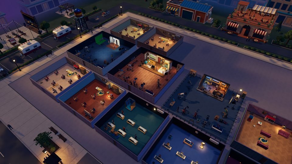 Grand Movie Tycoon at dusk: a film studio lot with writers' rooms, sound stages, a sitcom set, an editing suite and an outdoor action set